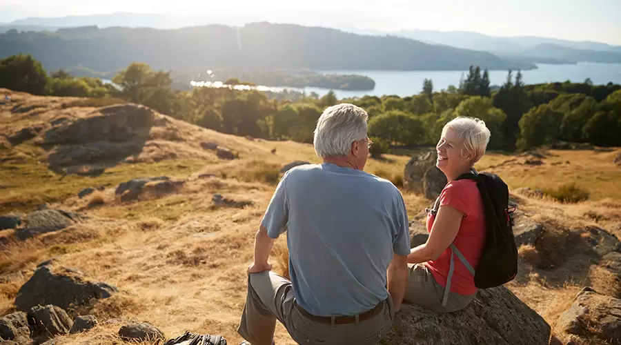 Older couple sat on rock looking over national park